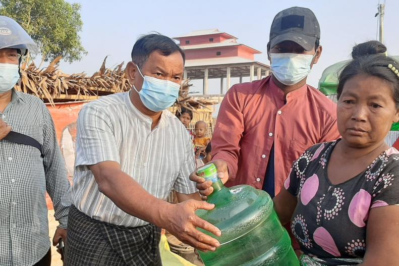  ပုံအညွှန်း - ဖယ်ရှားခံရသူများကို  ရခိုင်ပြည်လွတ်မြောက်ရေးပါတီ သောက်ရေးဗူးကြီး တစ်ဗူးစီ လှူဒါန်းစဉ်